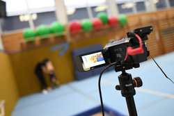 Eine Kamera ist auf Turnerinnen gerichtet. 