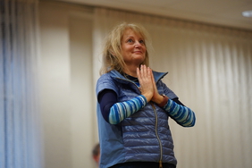 Eine Frau hat die Hände betend vor dem Körper.